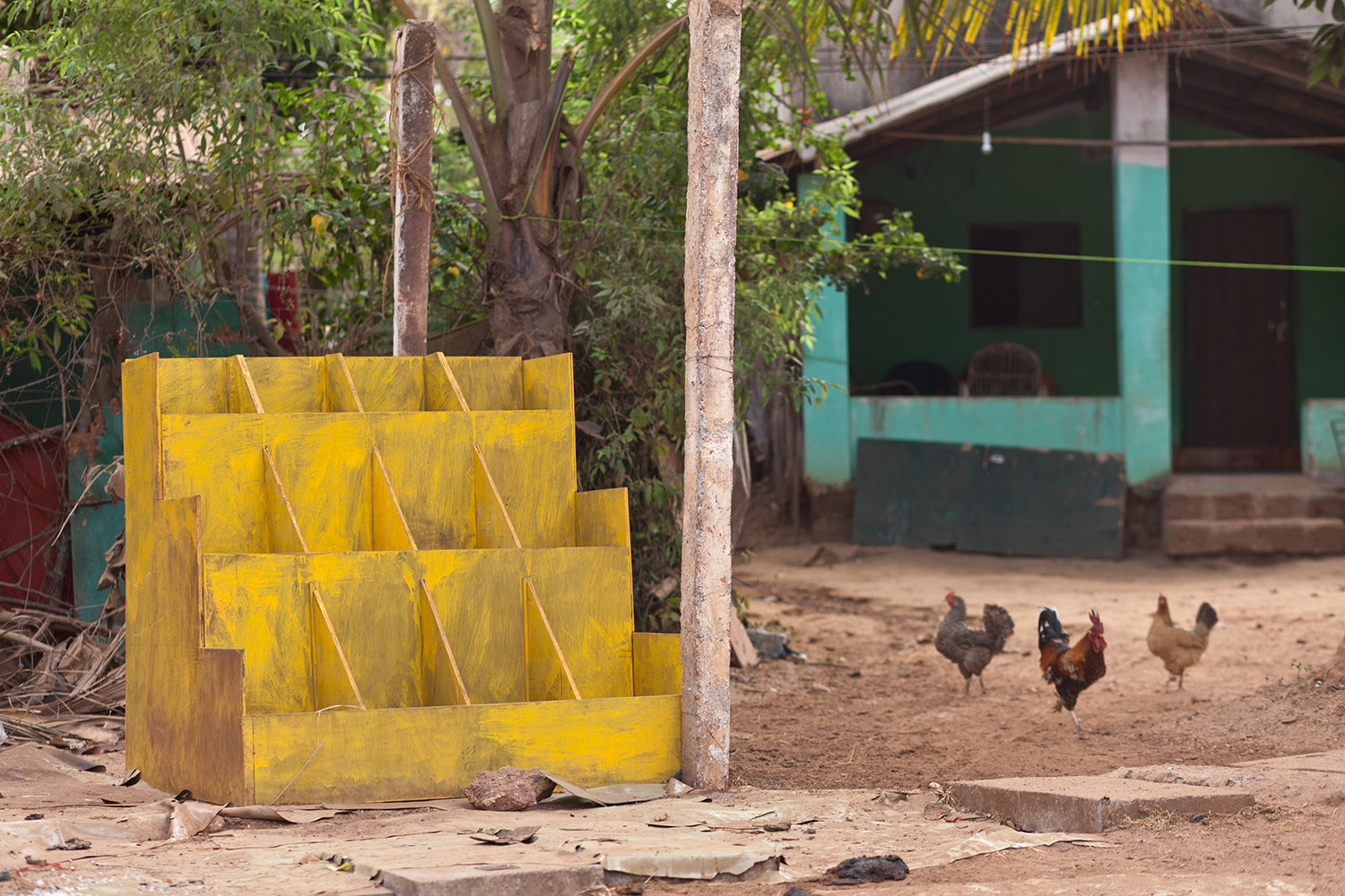 The light falls open a porch, the yellow of a side wall illuminated like a fried egg.
